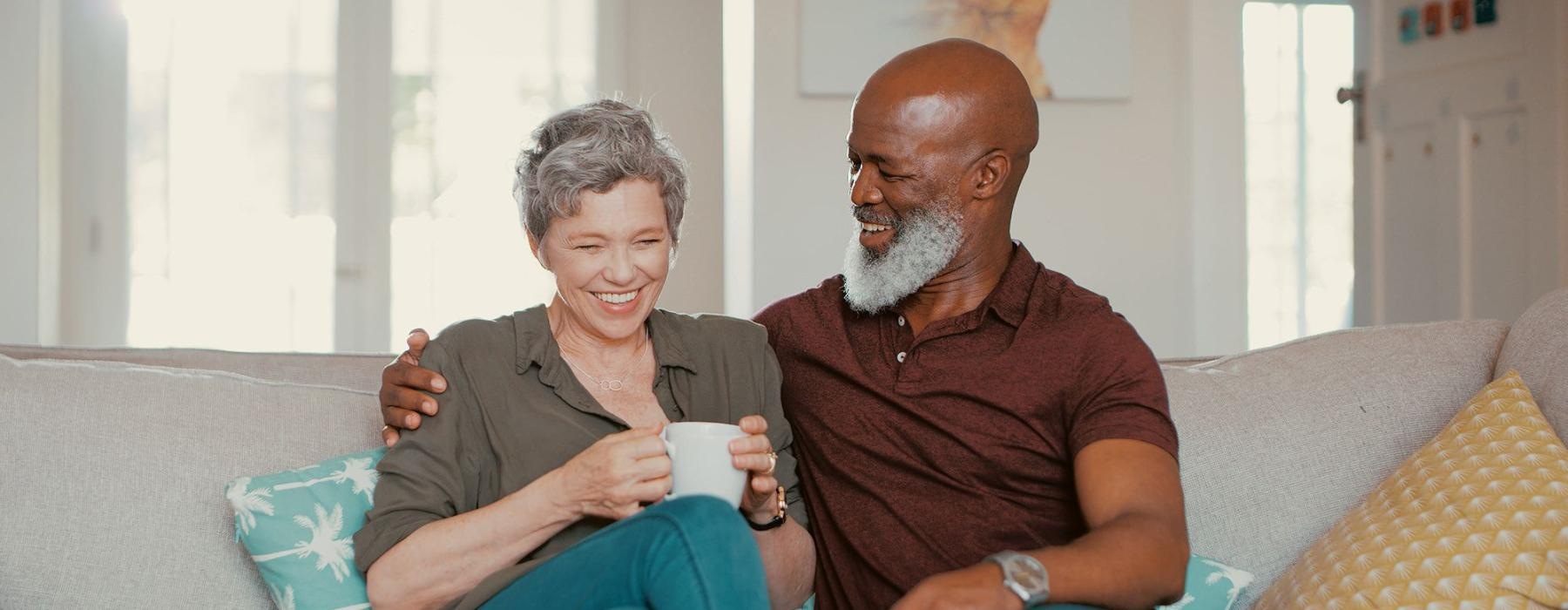 smiling, older couple, sit together on a couch