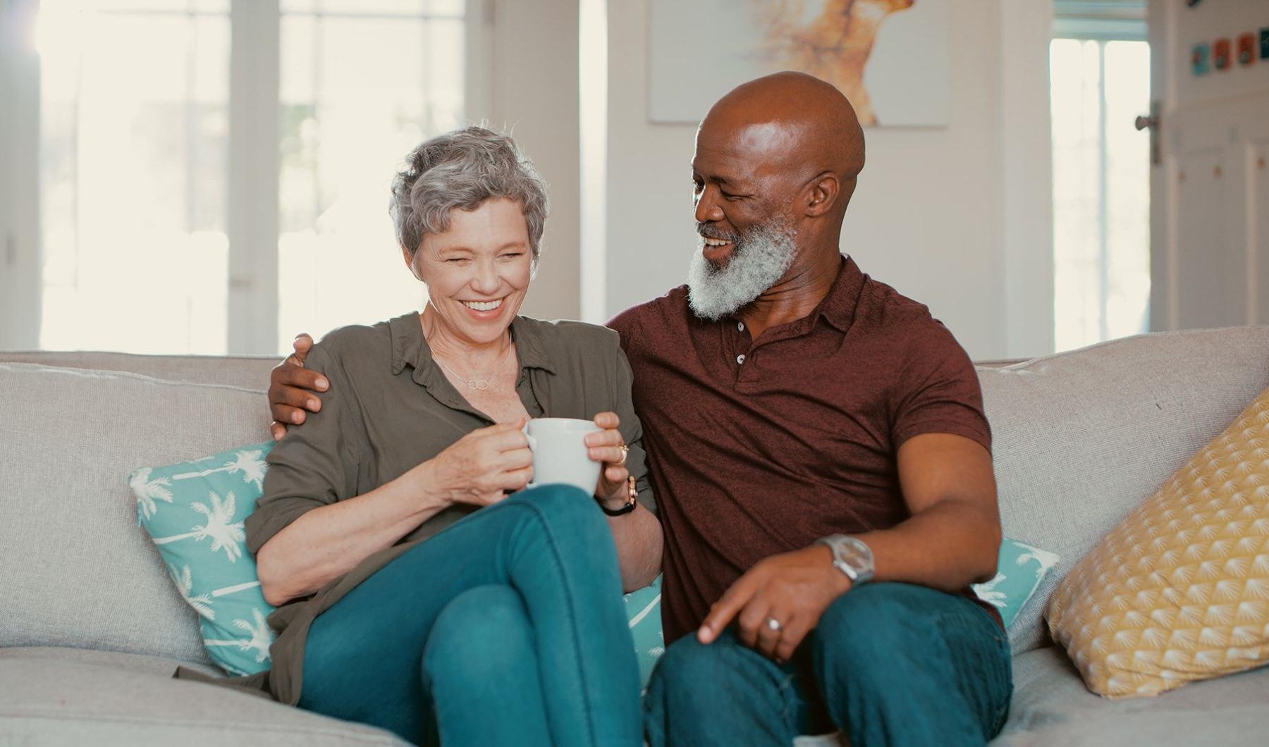 smiling, older couple, sit together on a couch