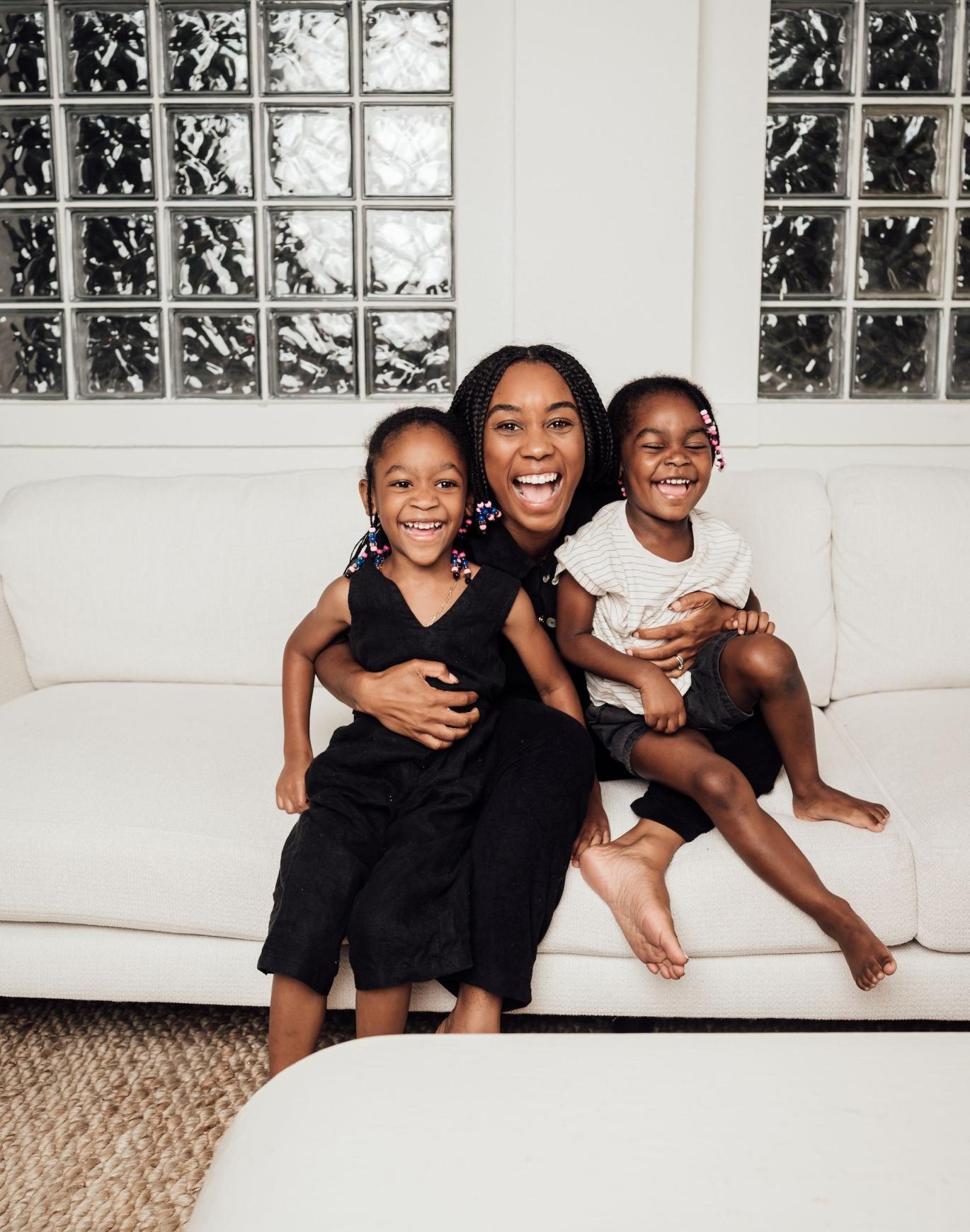 a woman sitting on a couch with two kids